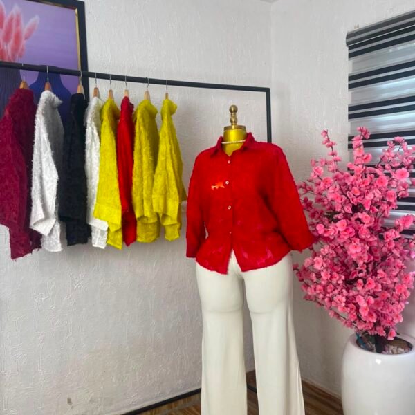 Red textured floral lace button-down corporate shirt styled with cream wide-leg trousers