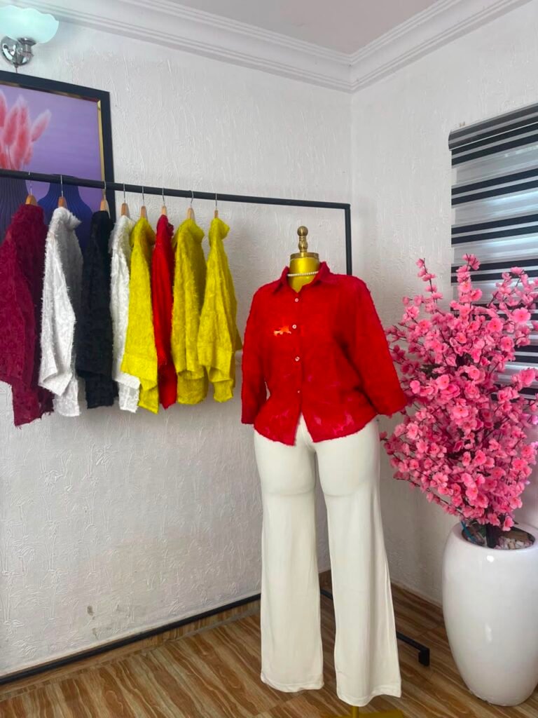 Red textured floral lace button-down corporate shirt styled with cream wide-leg trousers