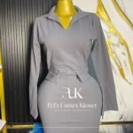 Grey long-sleeve corporate pencil dress with open collar, belted waist and back slit