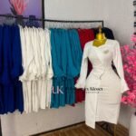 White wrap-front corporate pencil dress with sweetheart neckline, waist buttons and ruffle cuffs