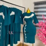 Teal corporate pencil dress with a white curved chest panel and white buttons down the side