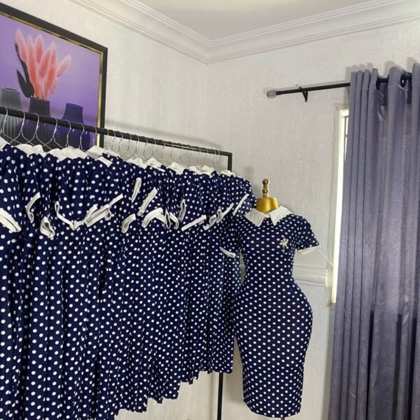 Navy blue and white polka dot corporate dress with a white Peter Pan collar and brooch