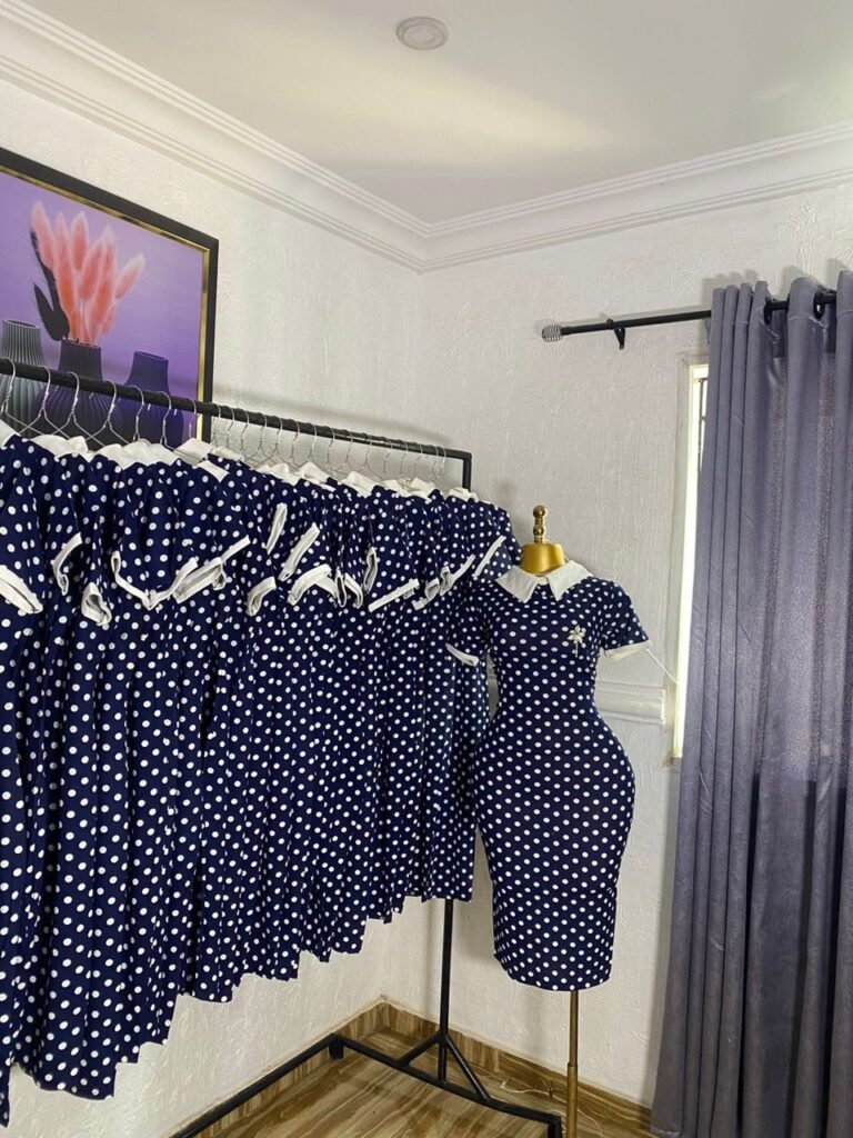 Navy blue and white polka dot corporate dress with a white Peter Pan collar and brooch