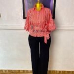 Red and white striped peplum shirt with a tie waist and gathered sleeves, worn with black wide-leg trousers