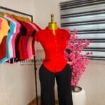 Red cap-sleeve button-front knit top styled with black tailored trousers